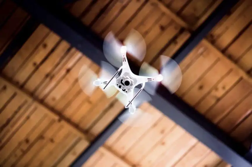White drone flying inside the building.