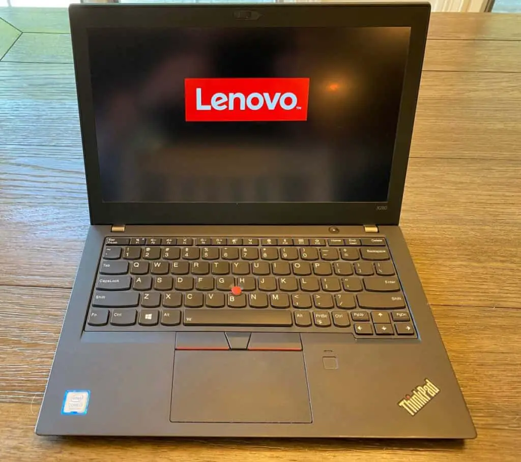 thinkpad laptop on wood table with lenovo logo