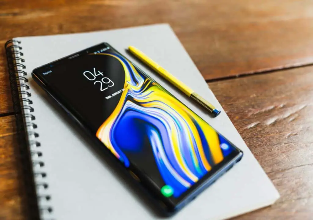 Galaxy Note 9 with yellow S pen stylus on a notebook