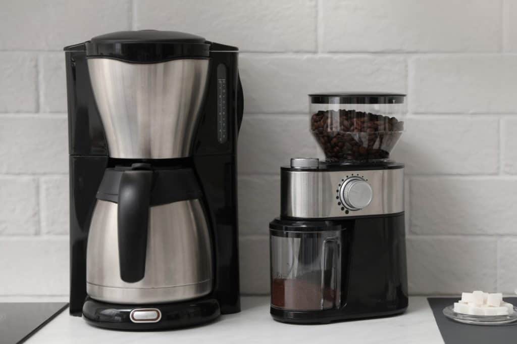 Modern coffee maker and grinder on counter in kitchen