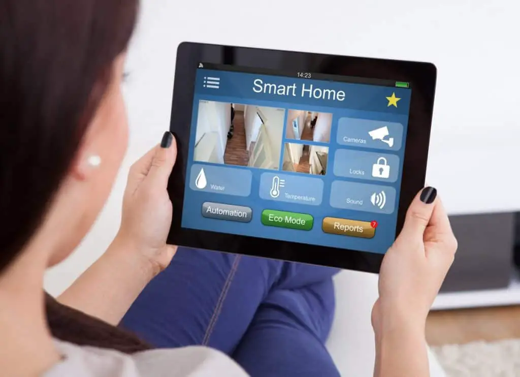Woman Using Smart Home System On Digital Tablet